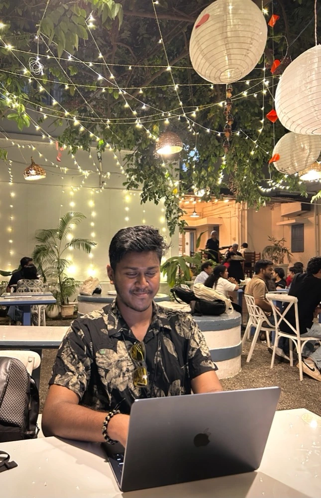 Soumya Ranjan working on a laptop at an outdoor café at night